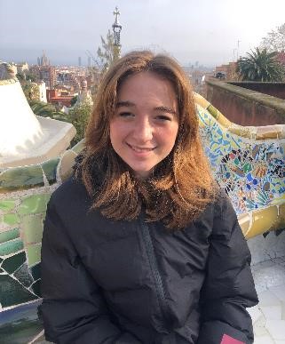Ava smiling in a winter coat on a bench