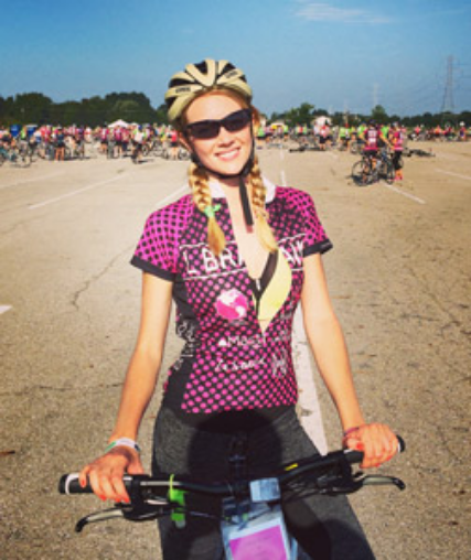 Lindsay standing with a bike ready for a bike race