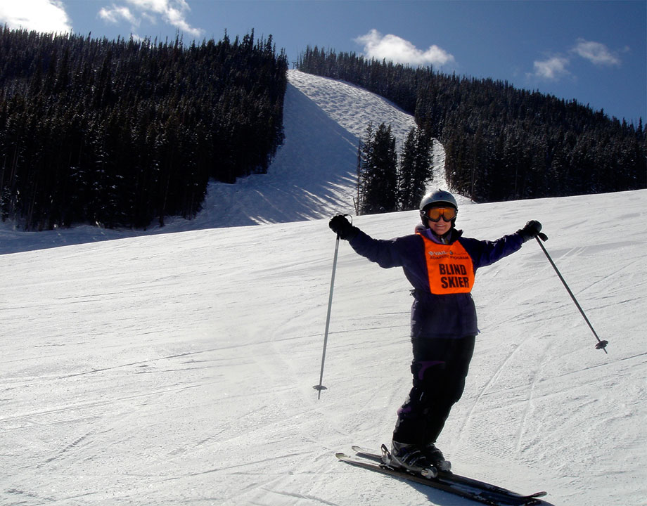 Marcia Skiing down a snow hill with her arms in the air